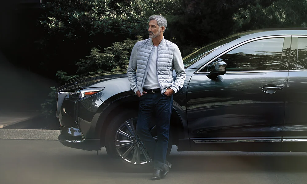 Mazda owner leaning against his SUV